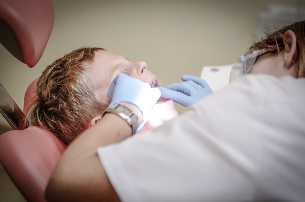 Pediatric dentist performing a child's regular dental examination